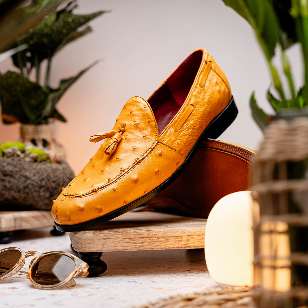 The Aubiere Buttercup by Marco Di Milano are yellow ostrich tassel loafers with red interior lining and branded leather soles, expertly crafted from genuine ostrich, presented against a white background.