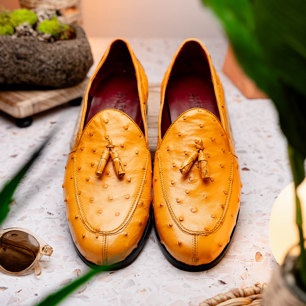 The Aubiere Buttercup by Marco Di Milano are yellow ostrich tassel loafers with red interior lining and branded leather soles, expertly crafted from genuine ostrich, presented against a white background.
