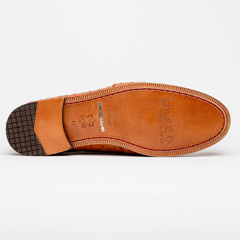 A pair of luxury men's footwear—Aubiere Cognac loafers by Marco Di Milano—boasts rich brown ostrich leather, with one shoe upright and the other on its side to reveal a sole stamped "Marco Di Milano.