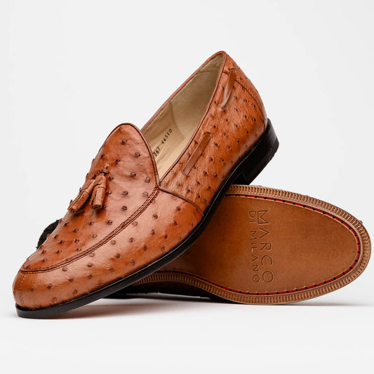 A pair of luxury men's footwear—Aubiere Cognac loafers by Marco Di Milano—boasts rich brown ostrich leather, with one shoe upright and the other on its side to reveal a sole stamped "Marco Di Milano.