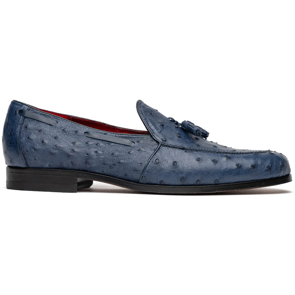 A pair of luxury men's footwear: the Aubiere Navy by Marco Di Milano—blue ostrich tassel loafers with red inner lining and brown leather soles, one shoe propped to display the sole branding.