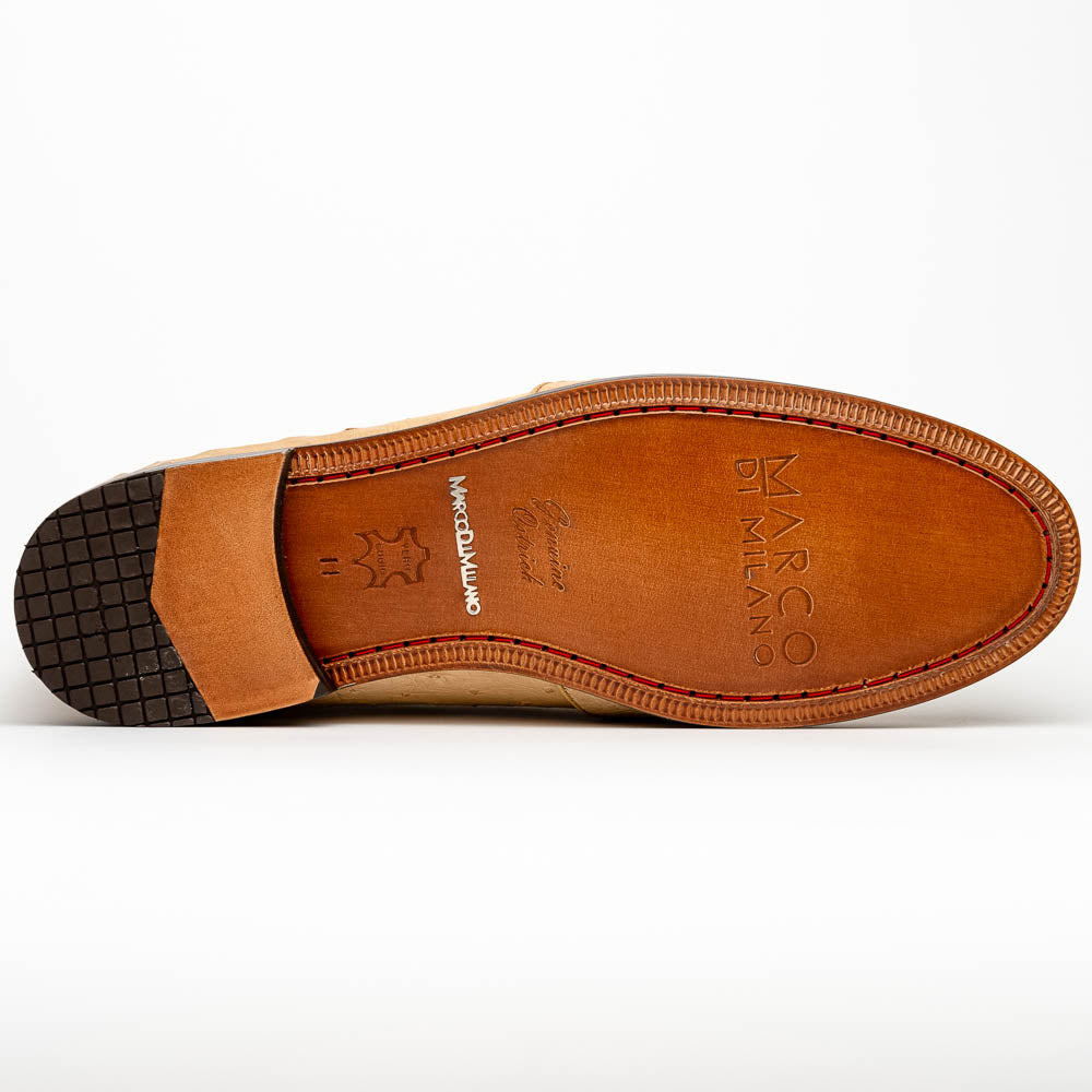The Aubiere Orix by Marco Di Milano features beige ostrich tassel loafers—one upright, one showing the stitched brown leather sole—ideal for luxury men’s footwear enthusiasts.