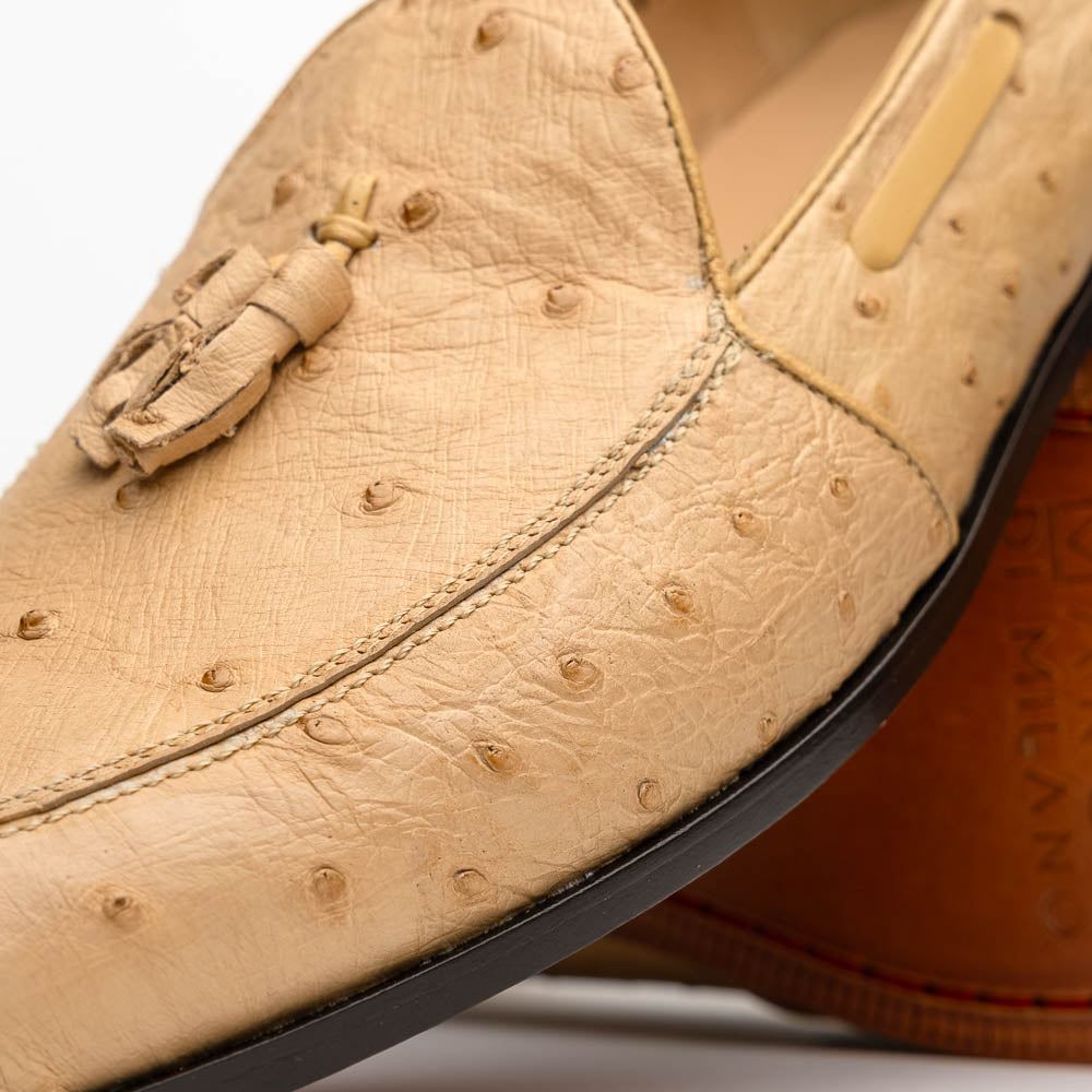 The Aubiere Orix by Marco Di Milano features beige ostrich tassel loafers—one upright, one showing the stitched brown leather sole—ideal for luxury men’s footwear enthusiasts.