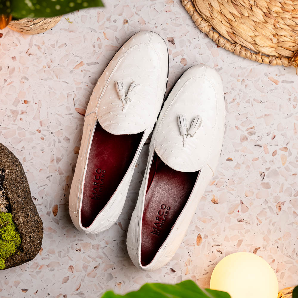 A pair of luxury men’s loafers—Marco Di Milano Aubiere White—crafted in textured white leather with ostrich tassels, red interior lining, tan soles; one shoe rests on its side showing the “Marco Di Milano” logo.