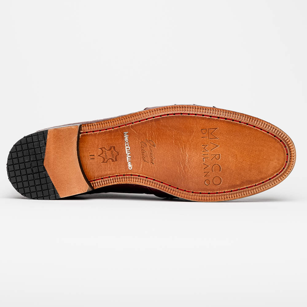 A pair of luxury Marco Di Milano Aubiere Wine loafers in burgundy ostrich leather—one upright showing tassels and quill detail, the other flipped to display the tan leather sole stamped “Marco Di Milano.”.
