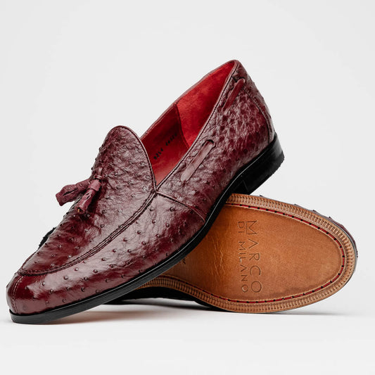 A pair of luxury Marco Di Milano Aubiere Wine loafers in burgundy ostrich leather—one upright showing tassels and quill detail, the other flipped to display the tan leather sole stamped “Marco Di Milano.”.