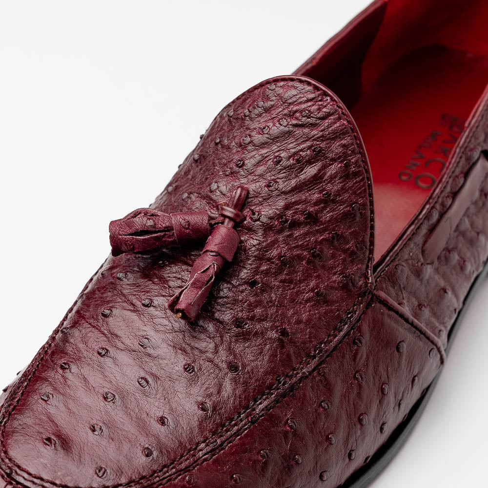 A pair of luxury Marco Di Milano Aubiere Wine loafers in burgundy ostrich leather—one upright showing tassels and quill detail, the other flipped to display the tan leather sole stamped “Marco Di Milano.”.