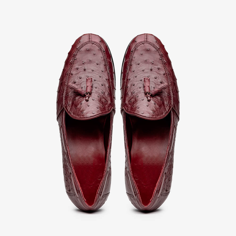 A pair of luxury Marco Di Milano Aubiere Wine loafers in burgundy ostrich leather—one upright showing tassels and quill detail, the other flipped to display the tan leather sole stamped “Marco Di Milano.”.
