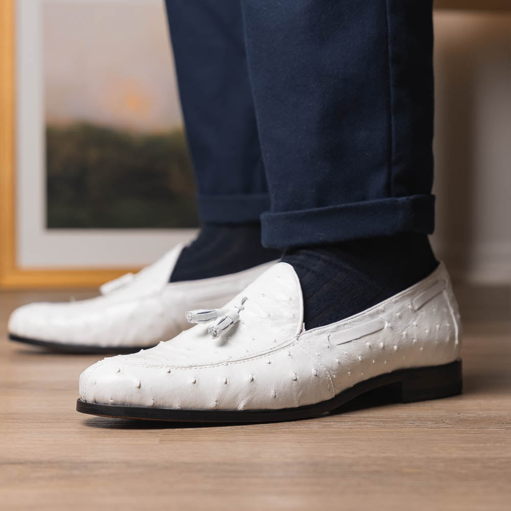 A pair of luxury men’s loafers—Marco Di Milano Aubiere White—crafted in textured white leather with ostrich tassels, red interior lining, tan soles; one shoe rests on its side showing the “Marco Di Milano” logo.