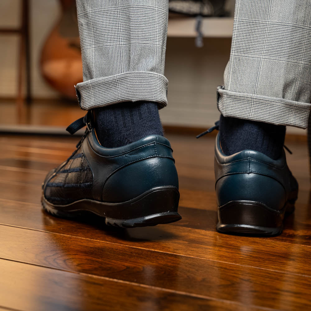 Bari Navy by Marco Di Milano: dark blue lace-up sneakers with a hand-painted finish, textured pattern, and rubber soles—one upright, one leaning. Enjoy luxury footwear designed for ultimate style and comfort.