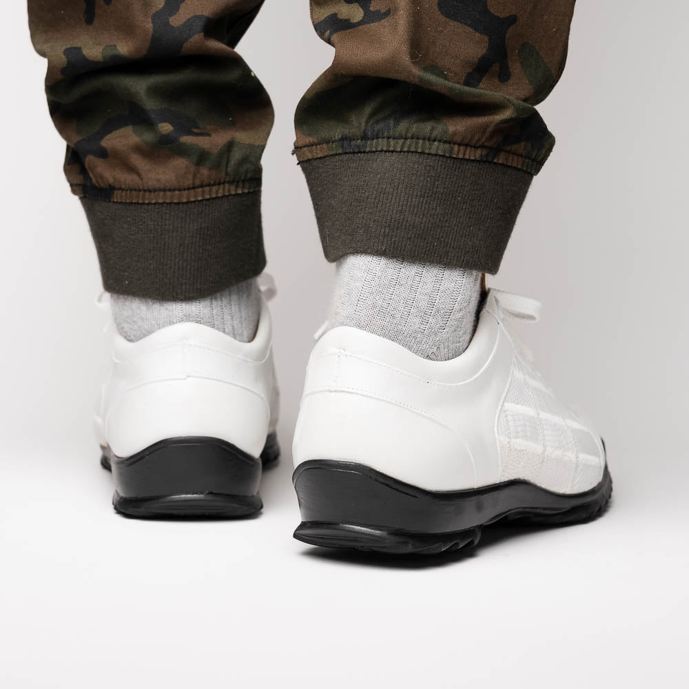 The Bari White by Marco Di Milano: white lace-up sneakers with a textured pattern, black rubber soles, and a metallic logo on the tongue. Displayed upright and angled to show the sole—luxury footwear defined.