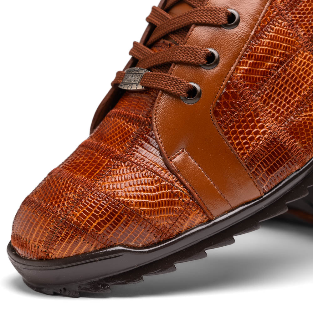The Marco Di Milano Bari Cognac features brown leather with a hand-painted finish, textured side panels, black laces, and black rubber soles—one shoe propped against the other.