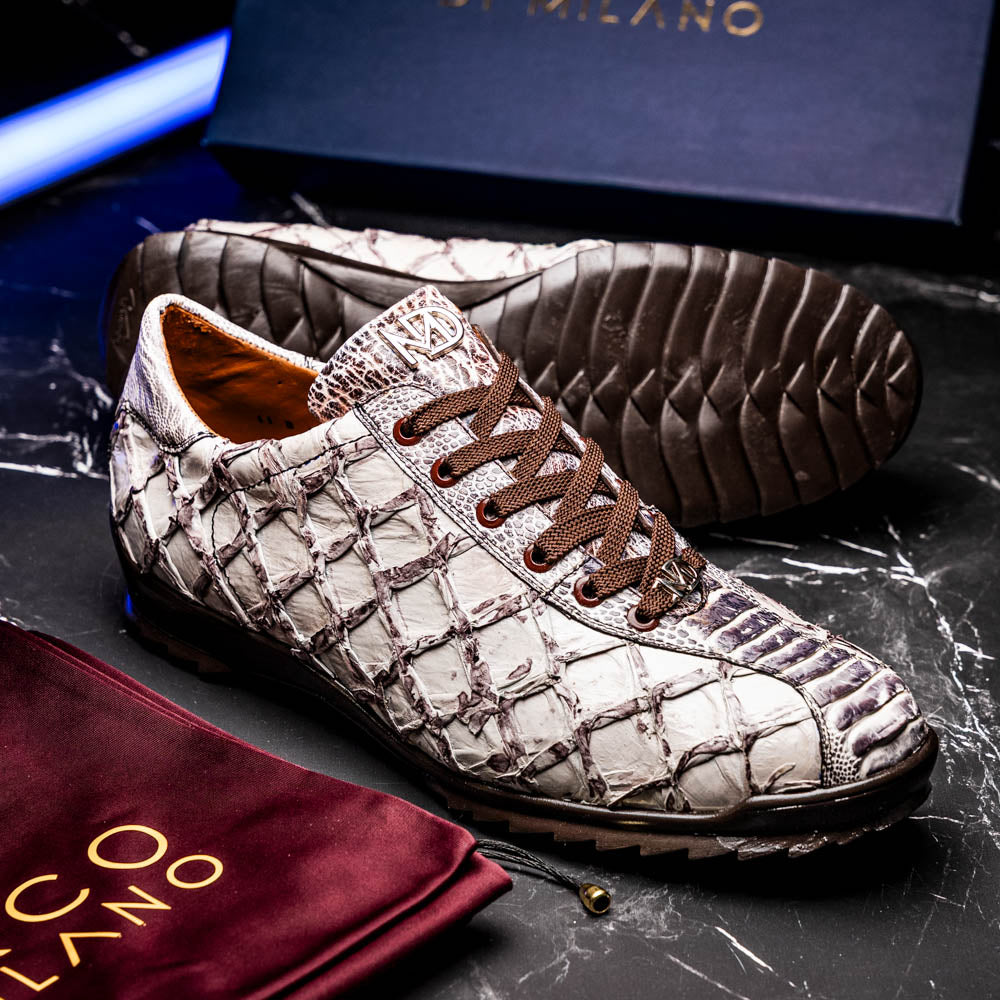 The Marco Di Milano Batistini Newspaper sneakers feature a white and grey crocodile-patterned texture, dark brown laces, and black rubber soles, showcased on a white background.