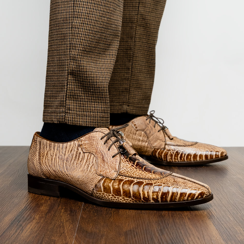 A pair of Belice Rustic Orix handcrafted leather oxford dress shoes by Marco Di Milano, fashioned from tan and brown crocodile leather—one shoe stands upright while the other lies on its side, displaying the sole.