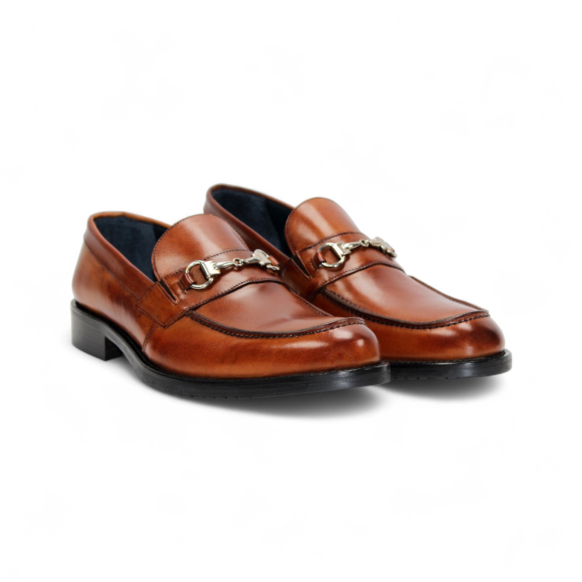 The Firmani Ben Cognac loafer by Firmani features genuine brown leather, a low black heel, and metal bit detail—ideal as a modern dress shoe for any occasion. Displayed on a white background.
