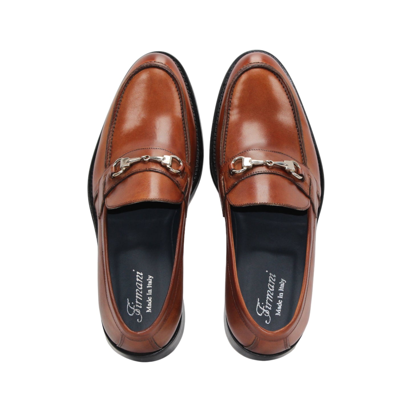 The Firmani Ben Cognac loafer by Firmani features genuine brown leather, a low black heel, and metal bit detail—ideal as a modern dress shoe for any occasion. Displayed on a white background.