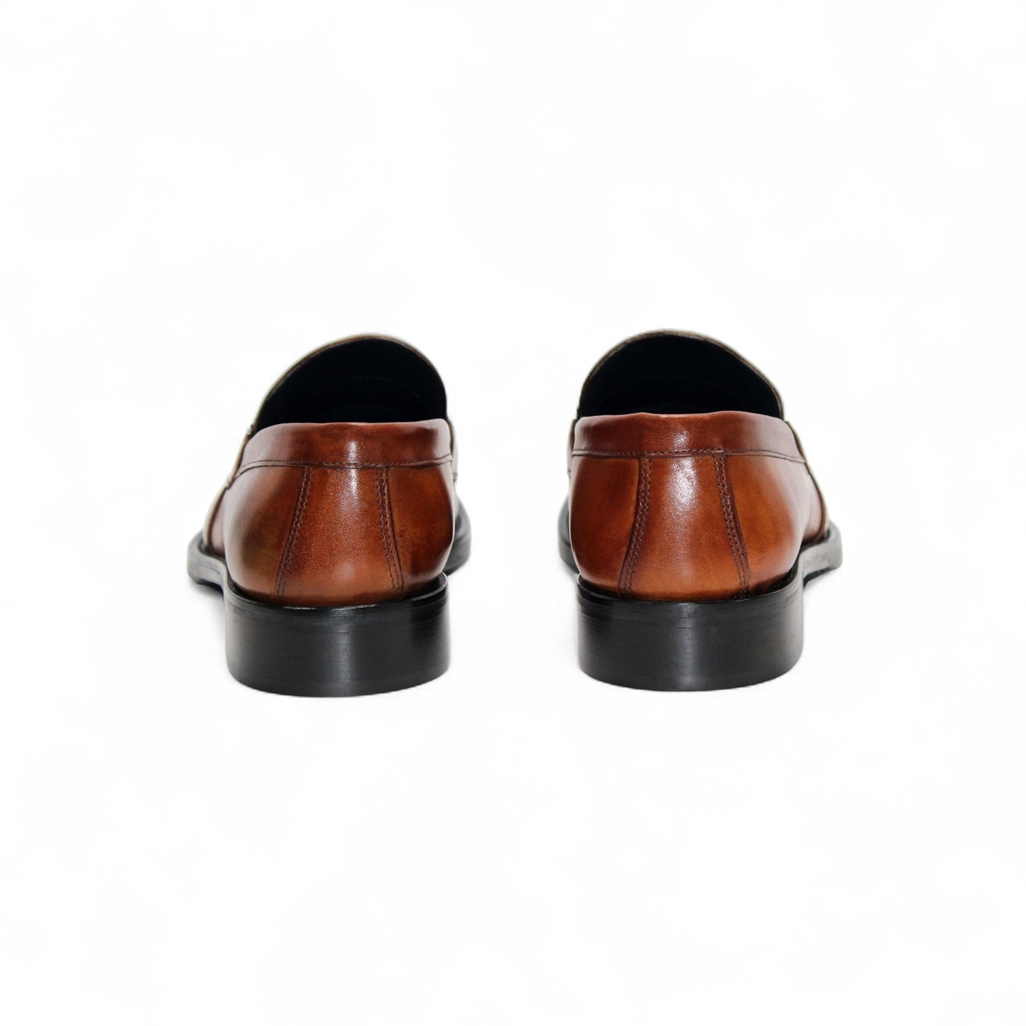 The Firmani Ben Cognac loafer by Firmani features genuine brown leather, a low black heel, and metal bit detail—ideal as a modern dress shoe for any occasion. Displayed on a white background.
