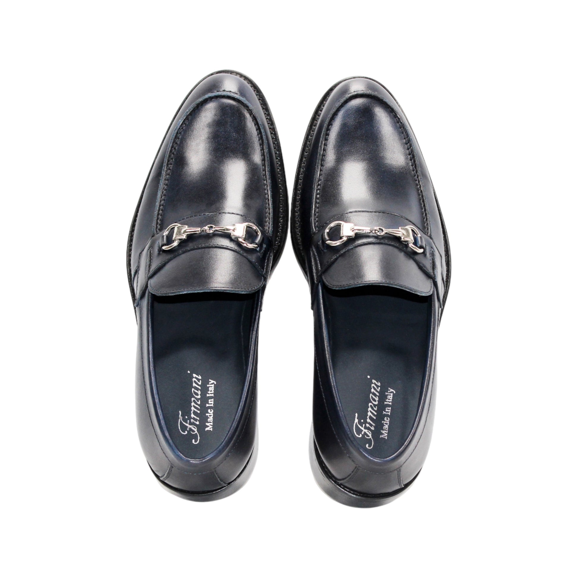 The Firmani Ben Navy by Firmani is a navy Italian leather loafer with a metal bit detail, low heel, and stitching accents, shown against a white background.