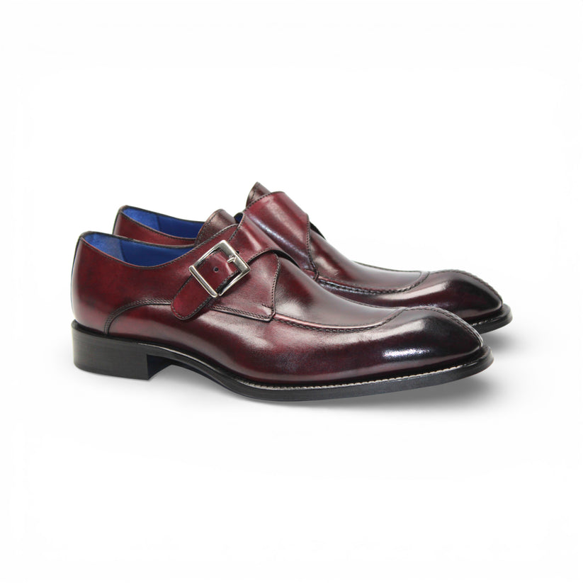 The Emilio Franco Bernardo Burgundy men's leather dress shoe features a silver buckle strap, black sole, and slight heel, stylishly displayed on a white background.