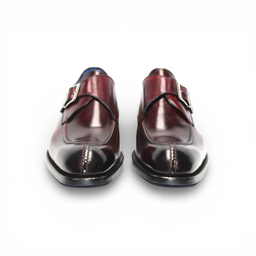 The Emilio Franco Bernardo Burgundy men's leather dress shoe features a silver buckle strap, black sole, and slight heel, stylishly displayed on a white background.