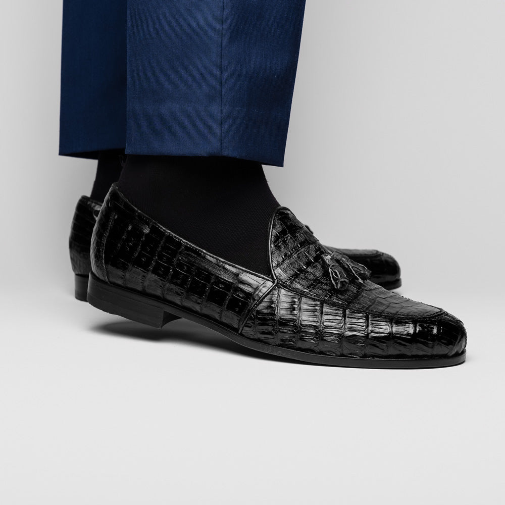 Experience luxury with the Marco Di Milano Bianchi Black—a pair of genuine caiman crocodile tassel loafers featuring black crocodile-patterned leather, red interior lining, and tan leather soles.