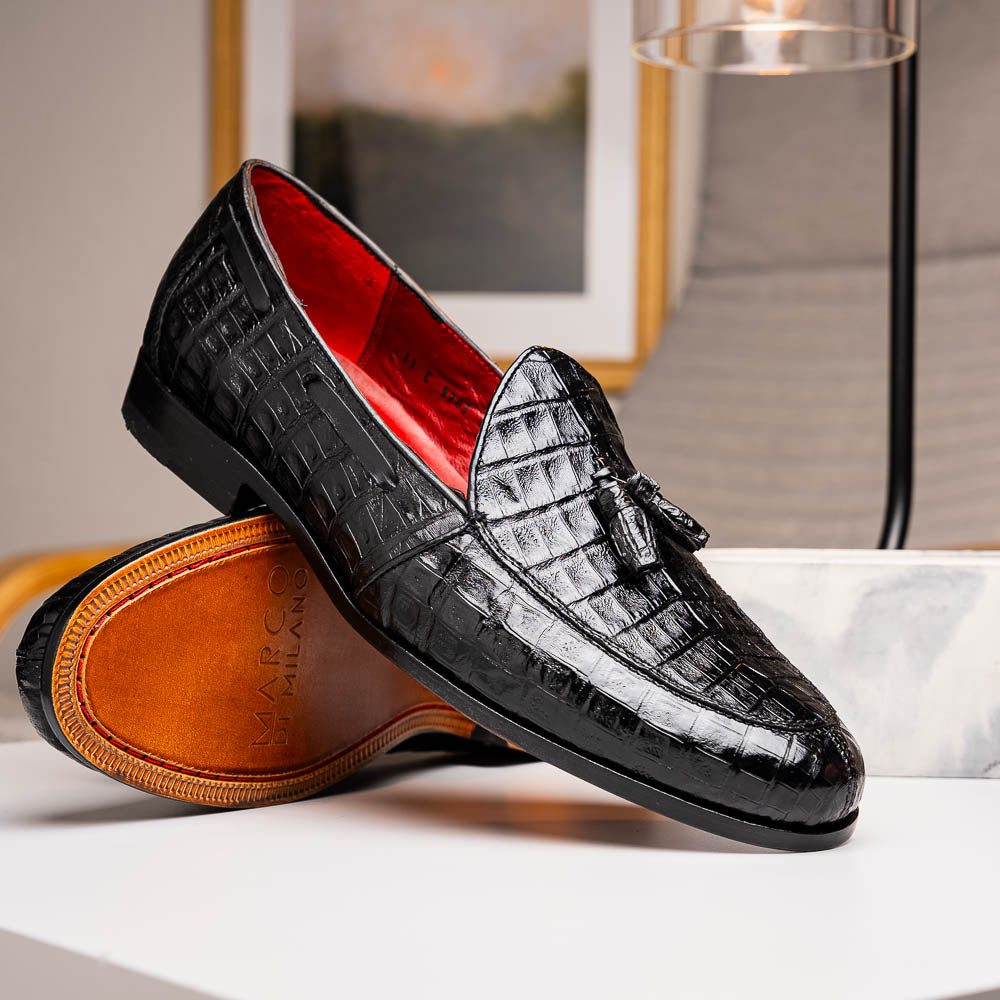 Experience luxury with the Marco Di Milano Bianchi Black—a pair of genuine caiman crocodile tassel loafers featuring black crocodile-patterned leather, red interior lining, and tan leather soles.