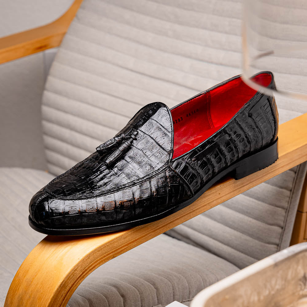 Experience luxury with the Marco Di Milano Bianchi Black—a pair of genuine caiman crocodile tassel loafers featuring black crocodile-patterned leather, red interior lining, and tan leather soles.