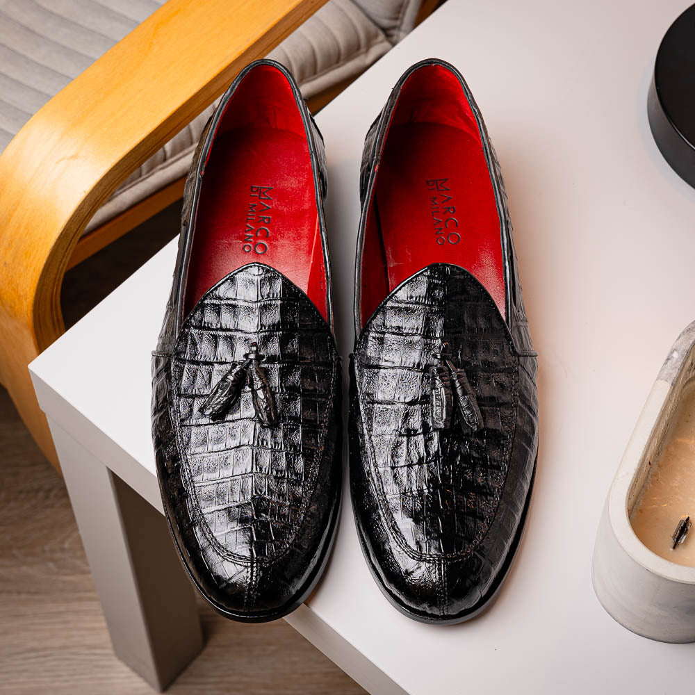 Experience luxury with the Marco Di Milano Bianchi Black—a pair of genuine caiman crocodile tassel loafers featuring black crocodile-patterned leather, red interior lining, and tan leather soles.