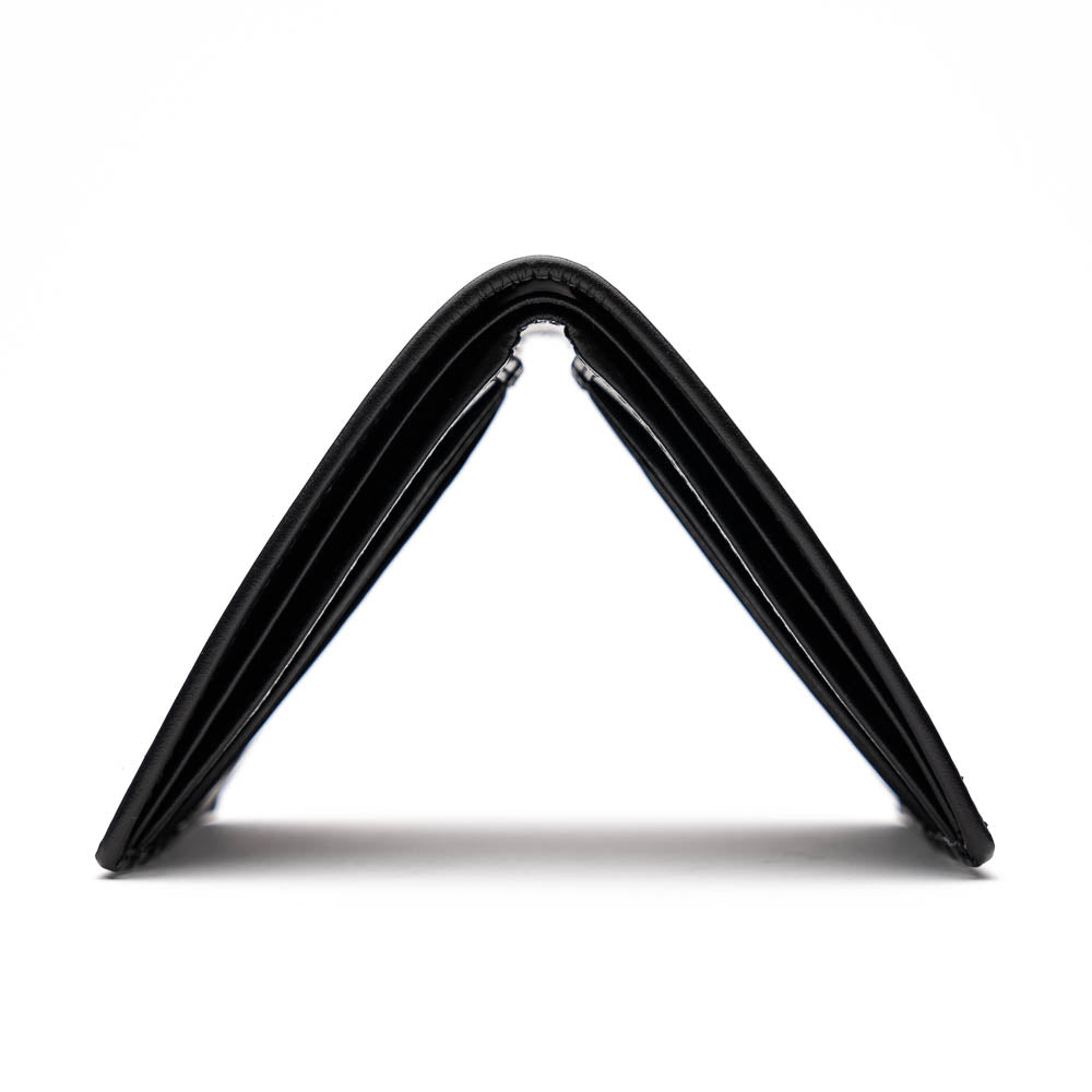 The Marco Di Milano Vallo Wallet Black is a textured luxury men's wallet with a central oval reflective accent, shown partially open on a white background.