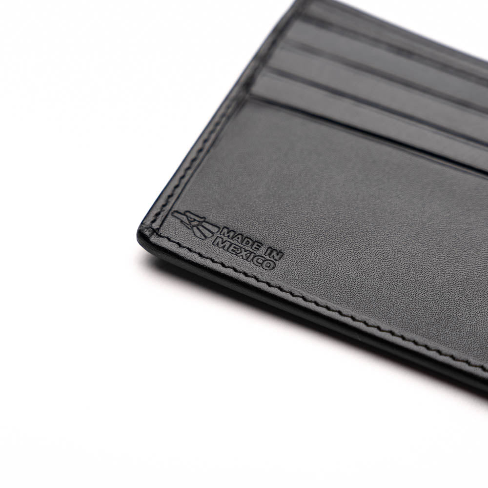The Marco Di Milano Vallo Wallet Black is a textured luxury men's wallet with a central oval reflective accent, shown partially open on a white background.