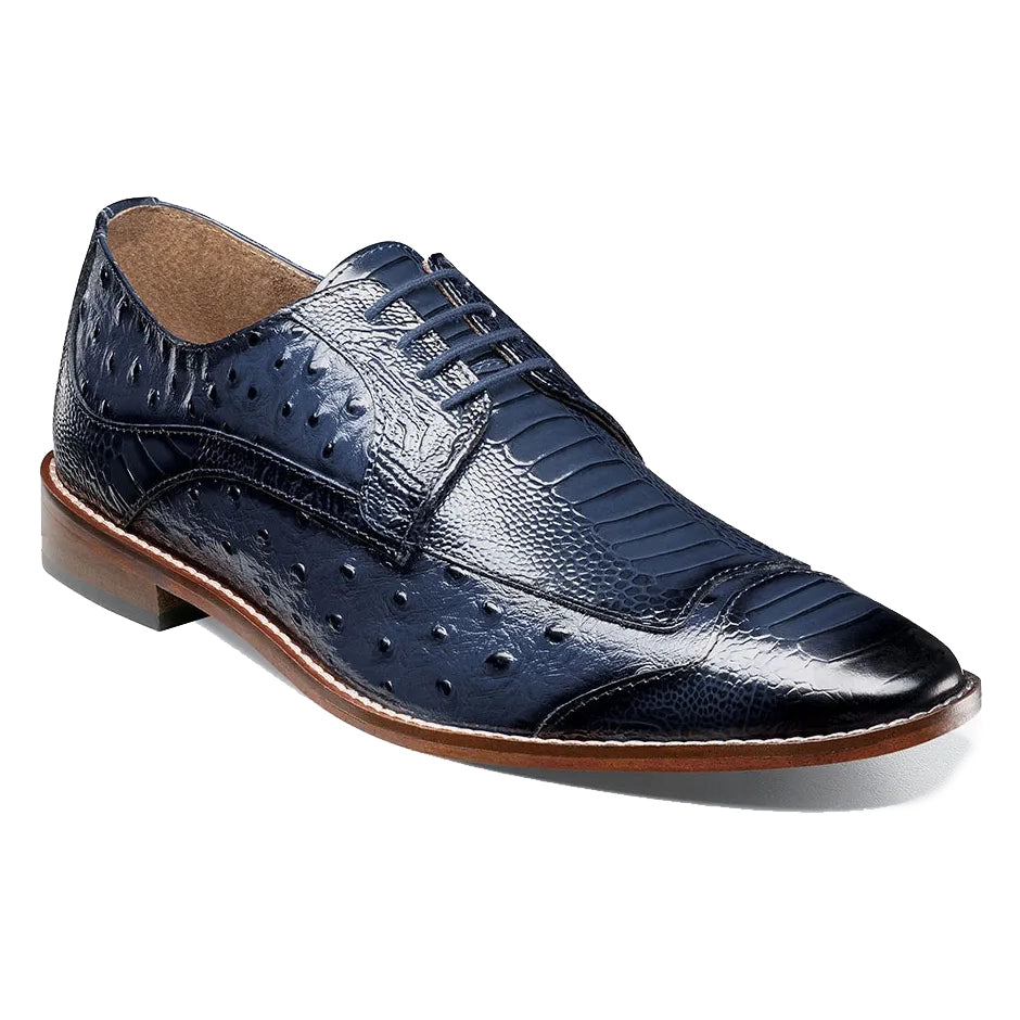 The Stacy Adams Fanelli Wing Tip Oxford in blue features a dark blue ostrich-style textured leather upper, brown sole, and closed lacing. Please note: this is a final sale item—no returns or exchanges.