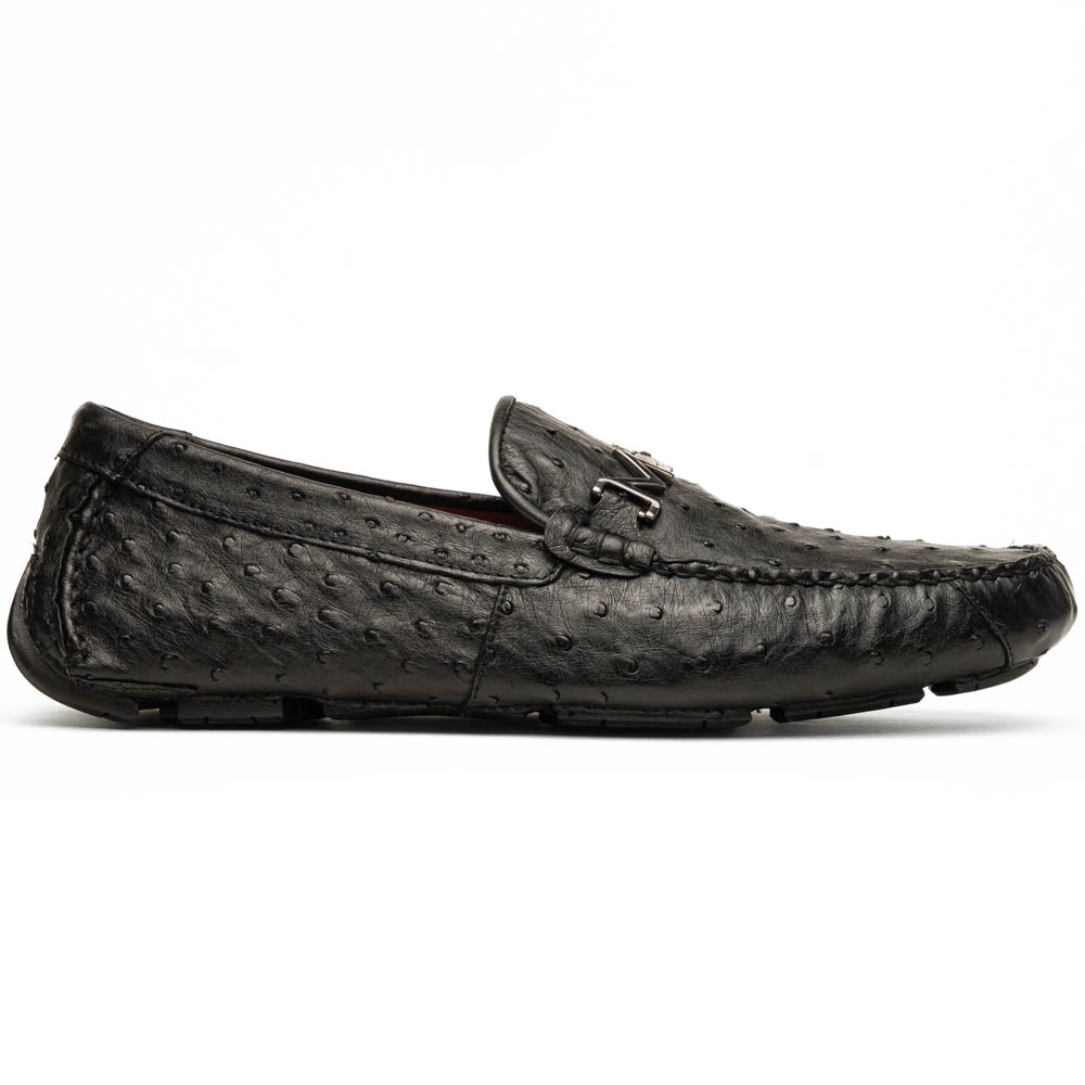 Bolonia Black by Marco Di Milano: a pair of black leather loafers with textured finish and metal buckle, one shoe upright and the other propped against it, displayed on a white background.