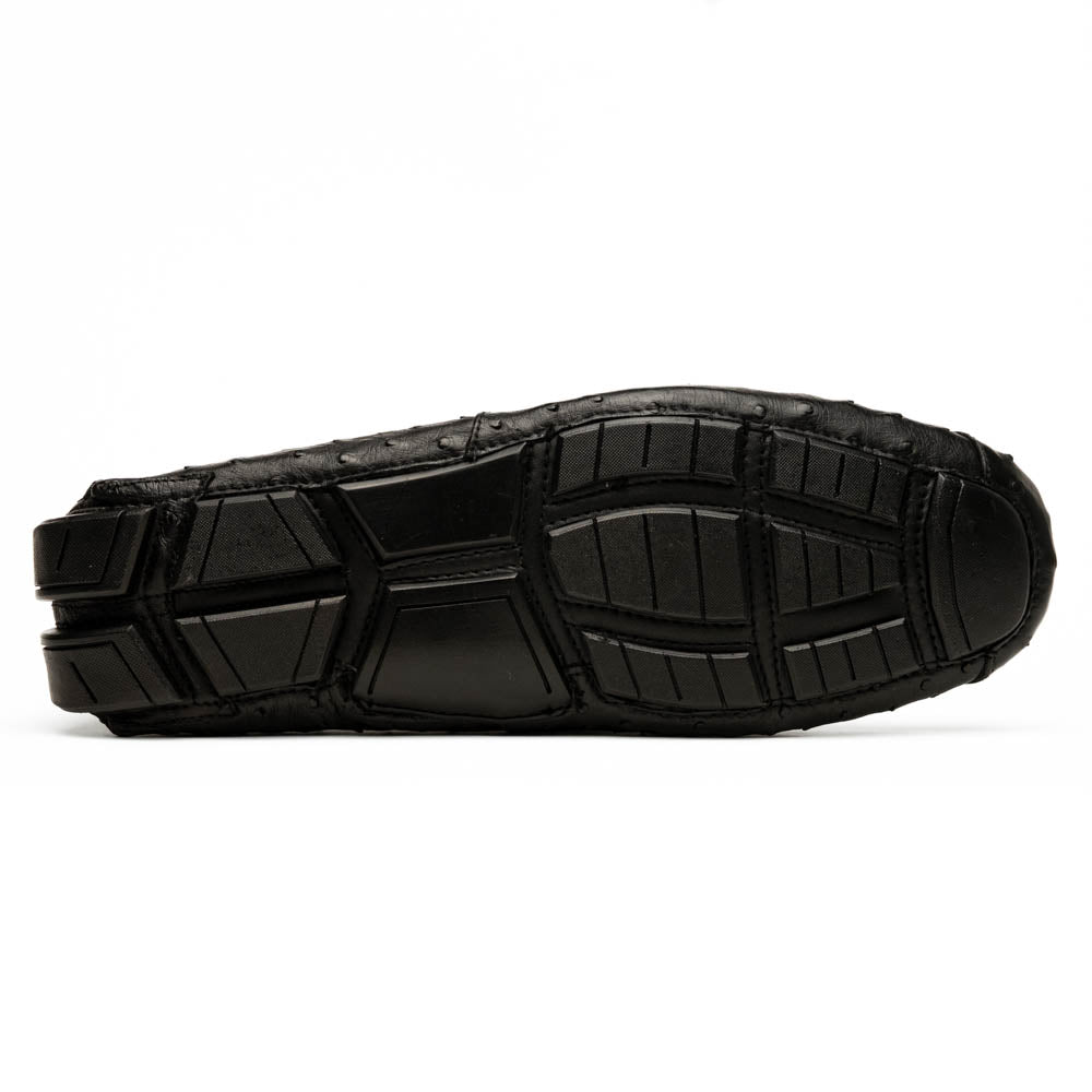 Bolonia Black by Marco Di Milano: a pair of black leather loafers with textured finish and metal buckle, one shoe upright and the other propped against it, displayed on a white background.