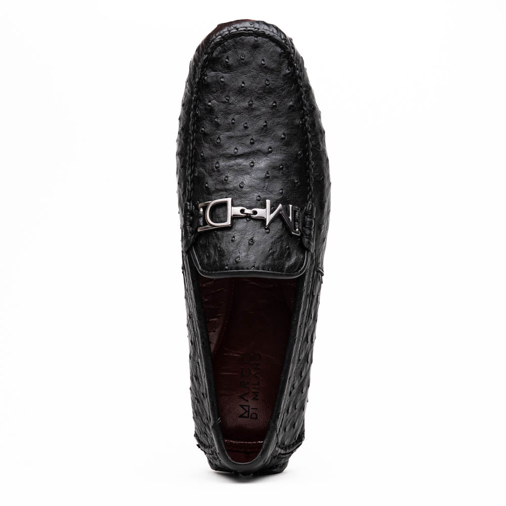 Bolonia Black by Marco Di Milano: a pair of black leather loafers with textured finish and metal buckle, one shoe upright and the other propped against it, displayed on a white background.