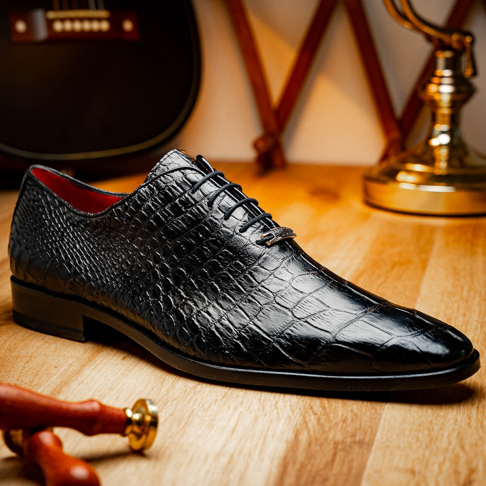 The Marco Di Milano Bono Black features a pair of luxury dress shoes in a crocodile pattern—one upright and one displaying a brown branded sole.