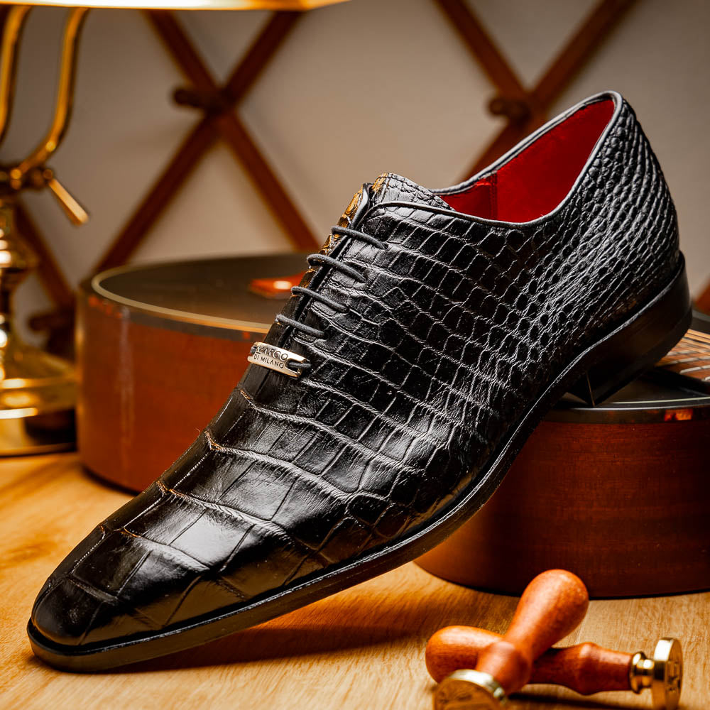 The Marco Di Milano Bono Black features a pair of luxury dress shoes in a crocodile pattern—one upright and one displaying a brown branded sole.
