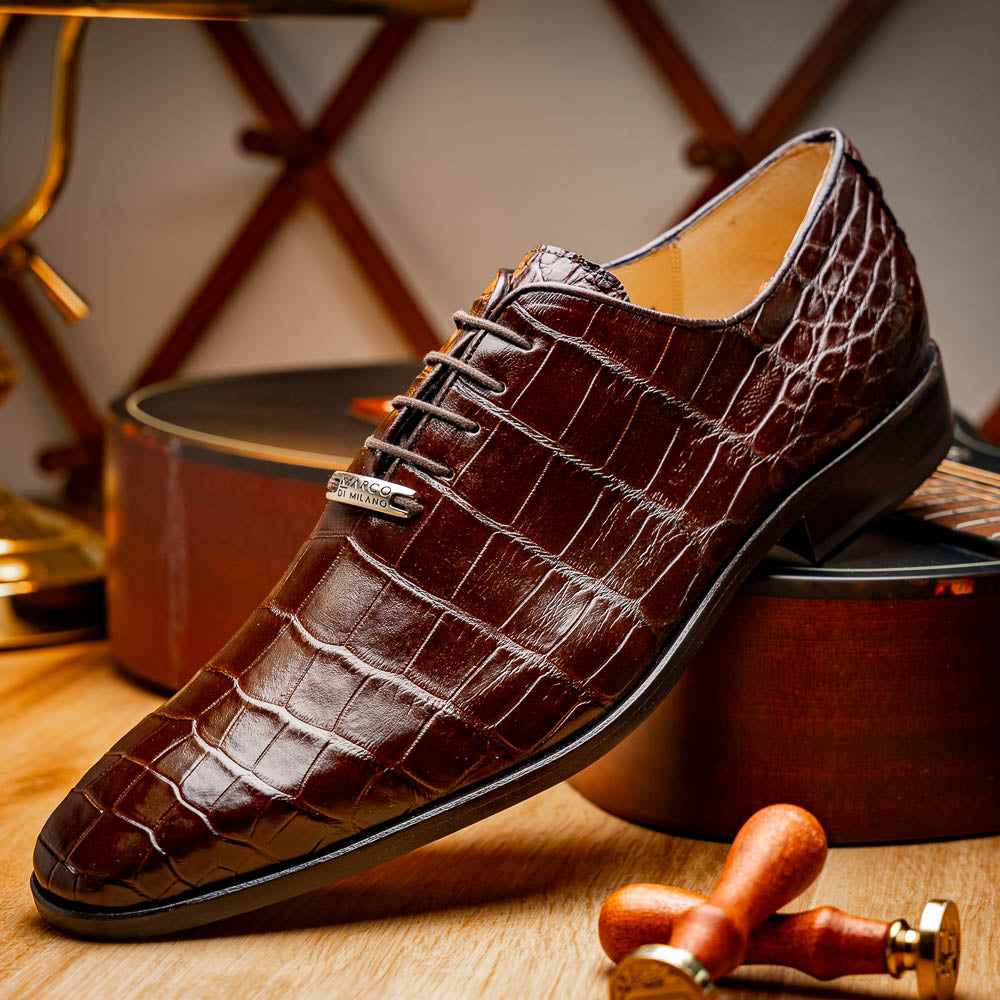 The Bono Brown by Marco Di Milano: genuine alligator Oxfords in brown—one upright displaying laces, the other showing the sole and stitching—a stunning example of luxury footwear.