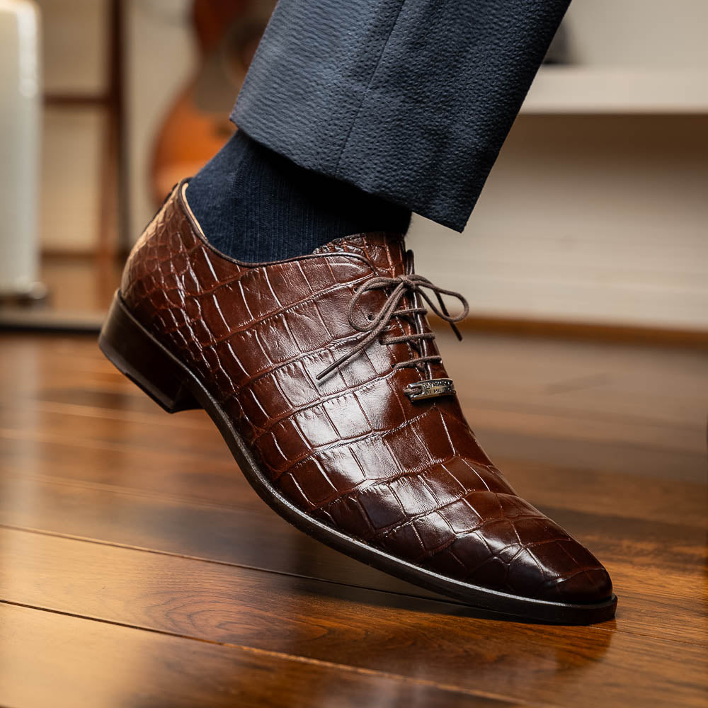The Bono Brown by Marco Di Milano: genuine alligator Oxfords in brown—one upright displaying laces, the other showing the sole and stitching—a stunning example of luxury footwear.