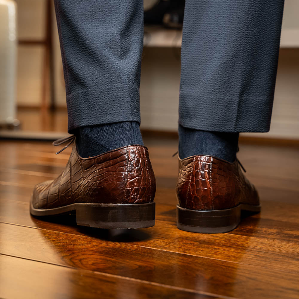 The Bono Brown by Marco Di Milano: genuine alligator Oxfords in brown—one upright displaying laces, the other showing the sole and stitching—a stunning example of luxury footwear.