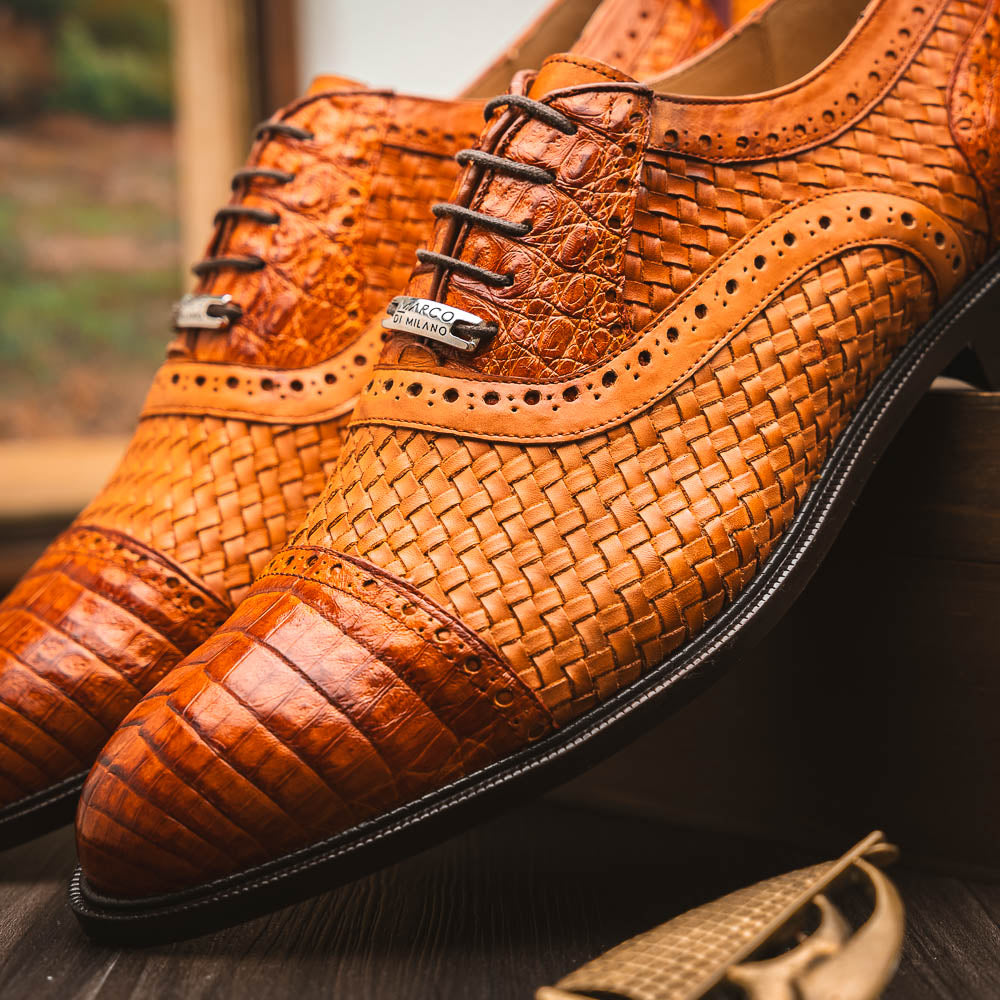 The John Brandy by Marco Di Milano is a pair of brown men’s oxford dress shoes with woven and textured leather, black laces, and stitched leather soles—ideal for those seeking luxury footwear.
