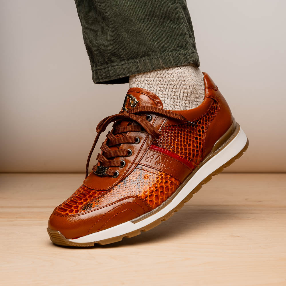 The Marco Di Milano Brescia Honey is a brown leather python fashion sneaker featuring a textured snakeskin pattern, red accent stripe, and thick rubber sole—luxury footwear redefined.