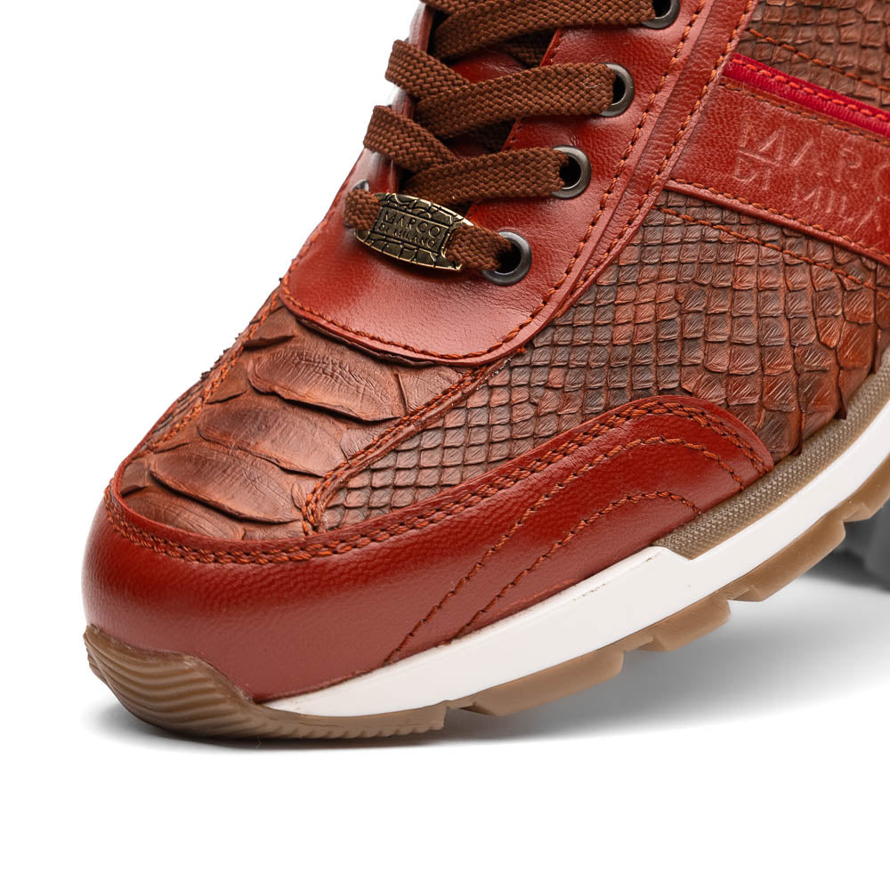The Marco Di Milano Brescia Antique Cognac sneakers feature brown textured leather, a patterned design, lace-up fronts, white midsoles, and tan rubber outsoles. One shoe is propped against the other.