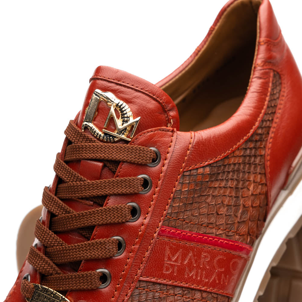 The Marco Di Milano Brescia Antique Cognac sneakers feature brown textured leather, a patterned design, lace-up fronts, white midsoles, and tan rubber outsoles. One shoe is propped against the other.