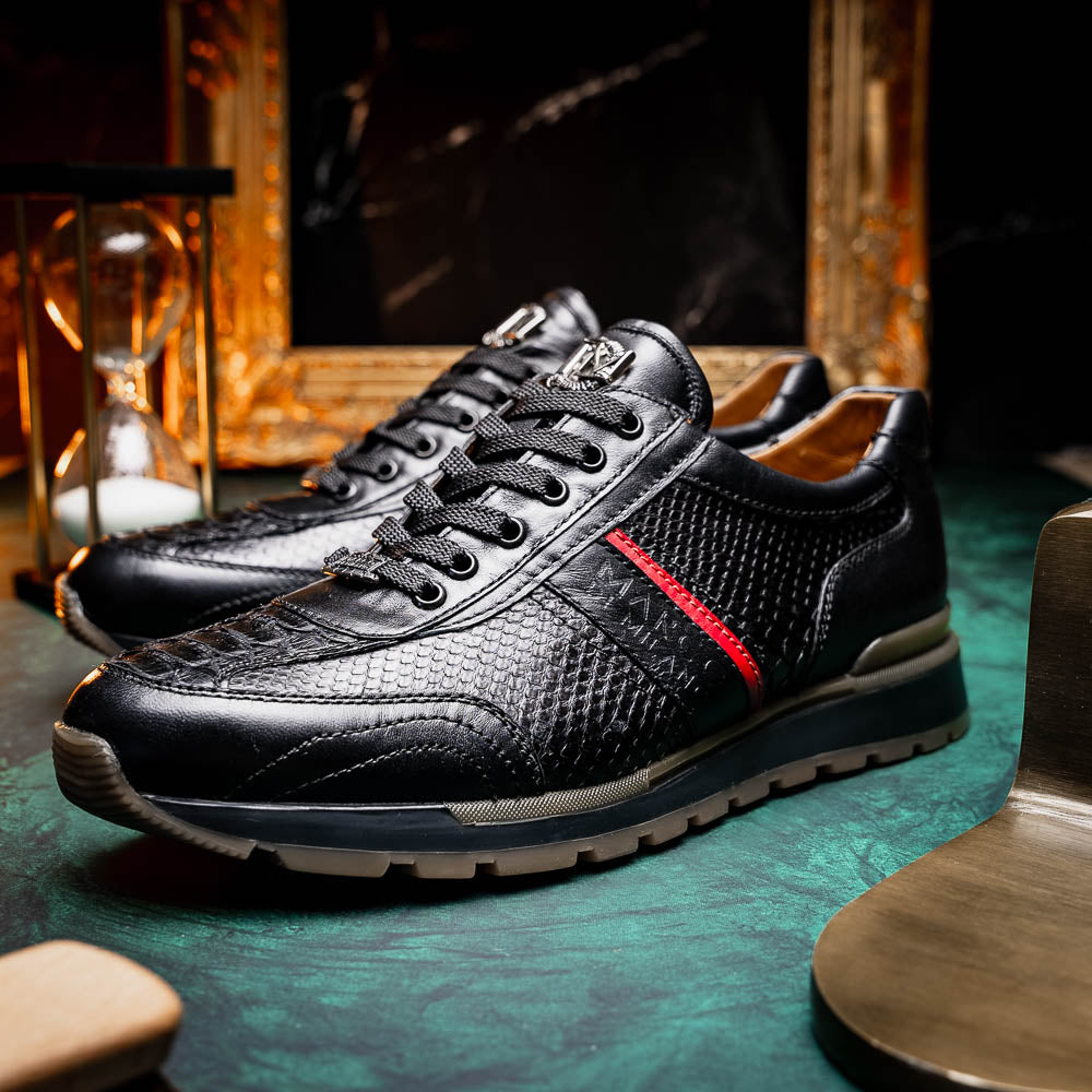 The Marco Di Milano Brescia Black sneakers feature textured black leather, black laces, a red side stripe, and brown rubber soles—one shoe stands upright while the other lies on its side.