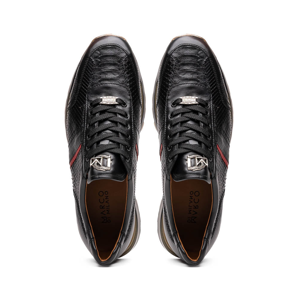 The Marco Di Milano Brescia Black sneakers feature textured black leather, black laces, a red side stripe, and brown rubber soles—one shoe stands upright while the other lies on its side.