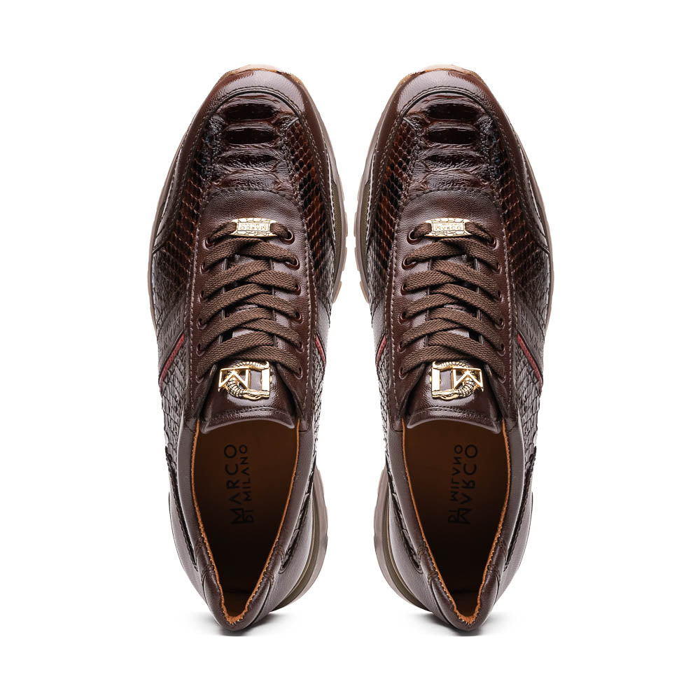 The Marco Di Milano Brescia Brown sneakers feature dark brown python-textured leather, a gold logo on the tongue, and a red stripe detail, with one shoe propped on the other—ideal for luxury footwear enthusiasts.