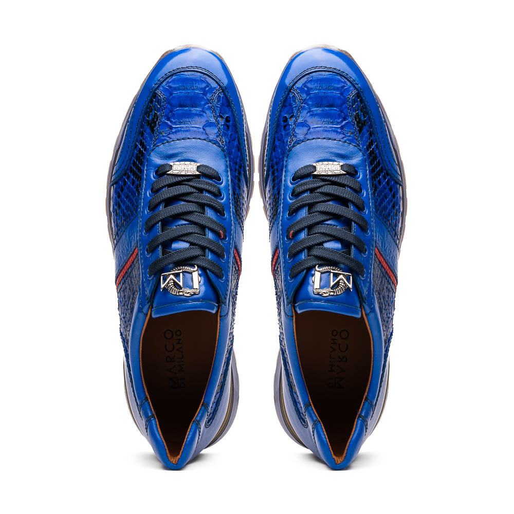 The Brescia Electric Blue sneakers by Marco Di Milano feature blue python leather, black laces, a red stripe, hand-painted side panels, and brown rubber soles—displayed with one shoe upright and the other on its side.
