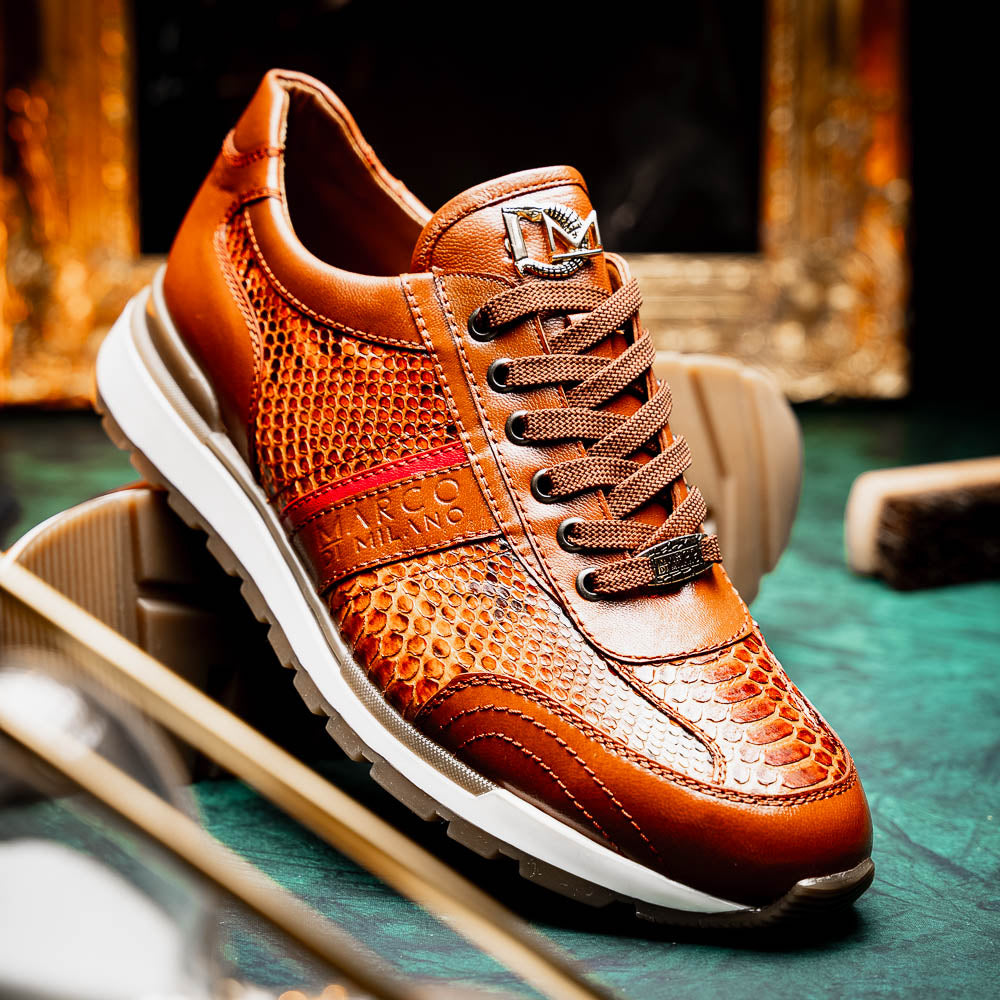 The Marco Di Milano Brescia Honey is a brown leather python fashion sneaker featuring a textured snakeskin pattern, red accent stripe, and thick rubber sole—luxury footwear redefined.
