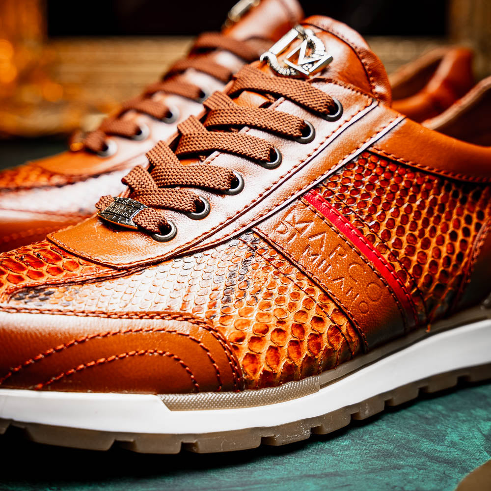 The Marco Di Milano Brescia Honey is a brown leather python fashion sneaker featuring a textured snakeskin pattern, red accent stripe, and thick rubber sole—luxury footwear redefined.