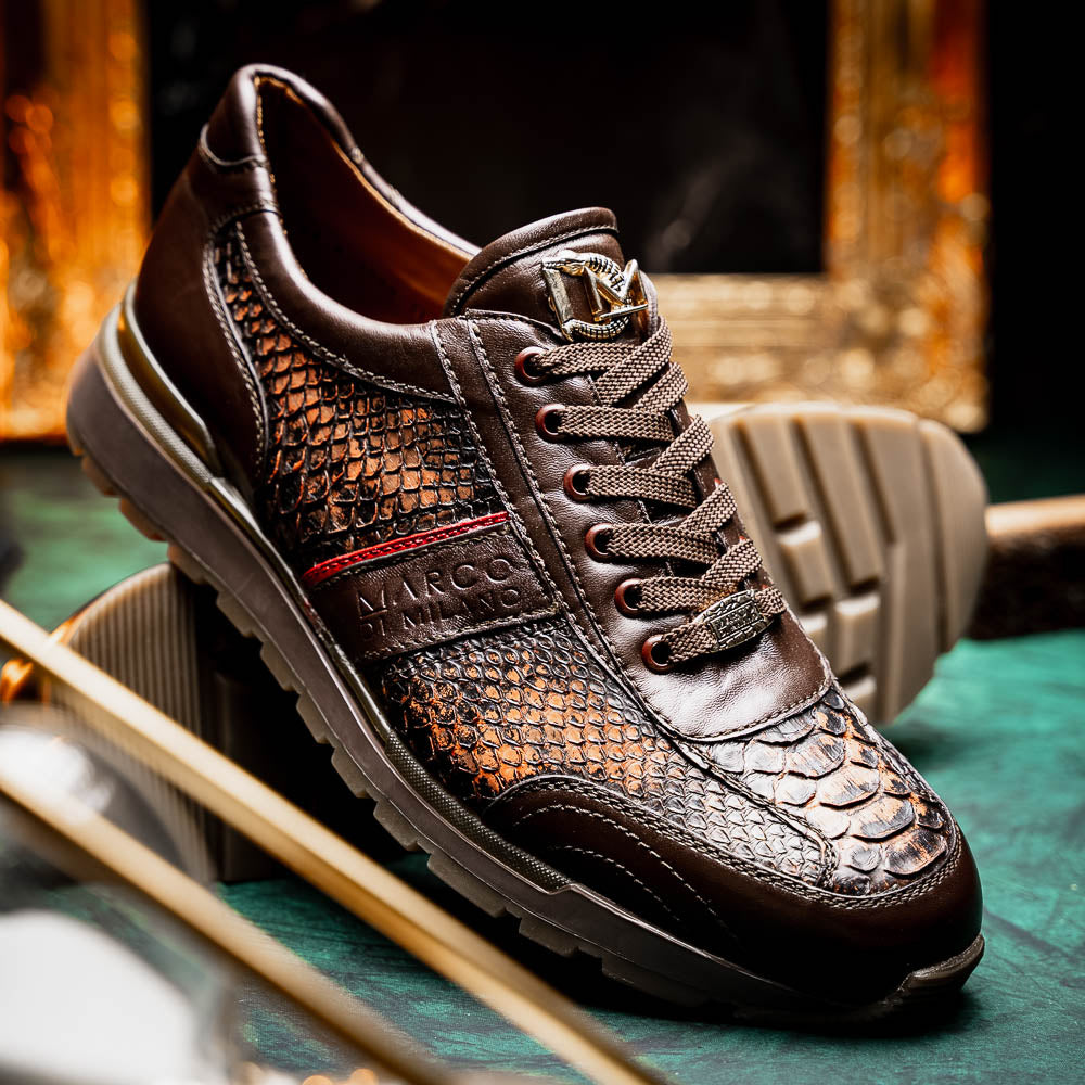 The Marco Di Milano Brescia Washed Cognac sneakers feature brown leather with a snakeskin pattern, gold accents, and rubber soles; one shoe is propped stylishly against the other, showcasing luxury footwear appeal.